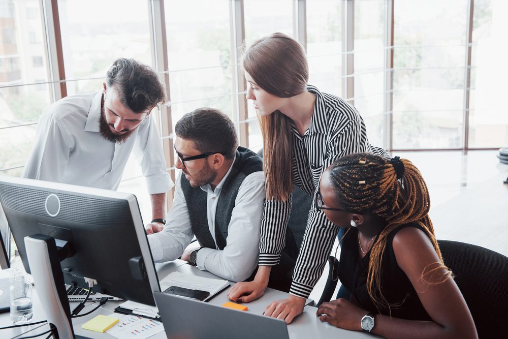 Equipo de profesionales colaborando frente a portátiles